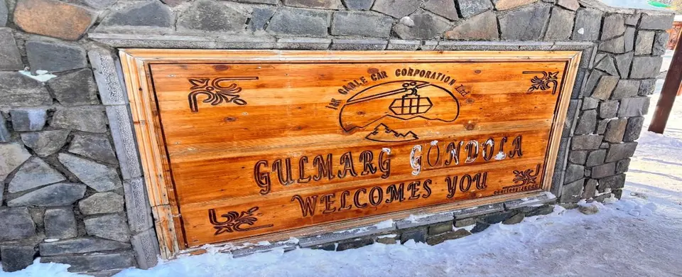 Wooden Gulmarg welcome sign in snow